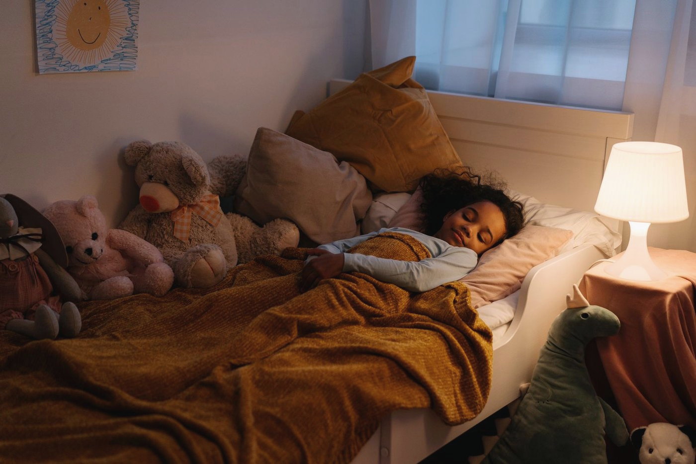 A child sleeping peacefully in warm lamplight.